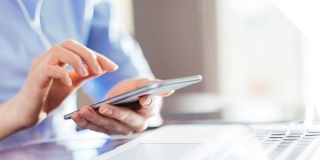 A sales representative is dealing with customer' E-mail with mobile.