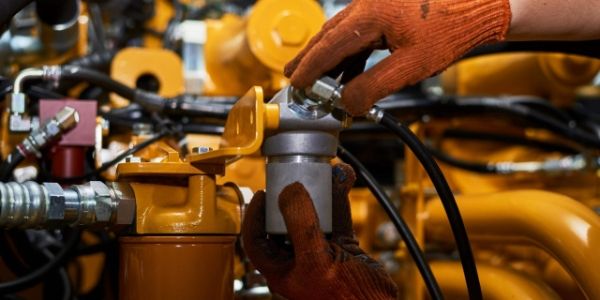 A technician is installed the hose assemblies onto the equipment.