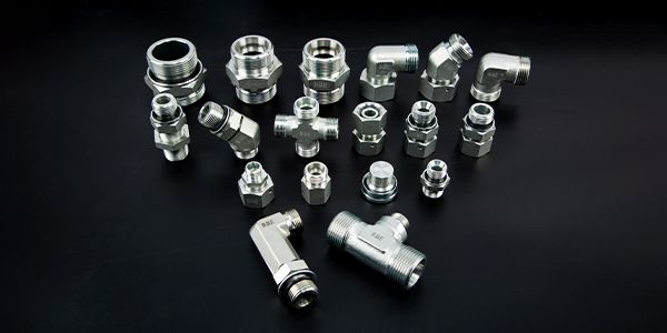 Several different types of hydraulic adaptors on black background.