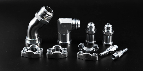 Several different types of hose flange fitting and adaptors on black background.