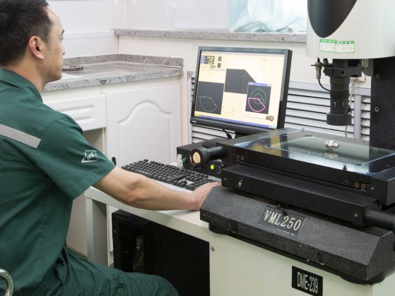 A worker is operating the image measurement test device.