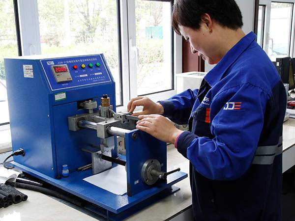 Our quality inspector is testing the abrasion resistance of the hydraulic hose.